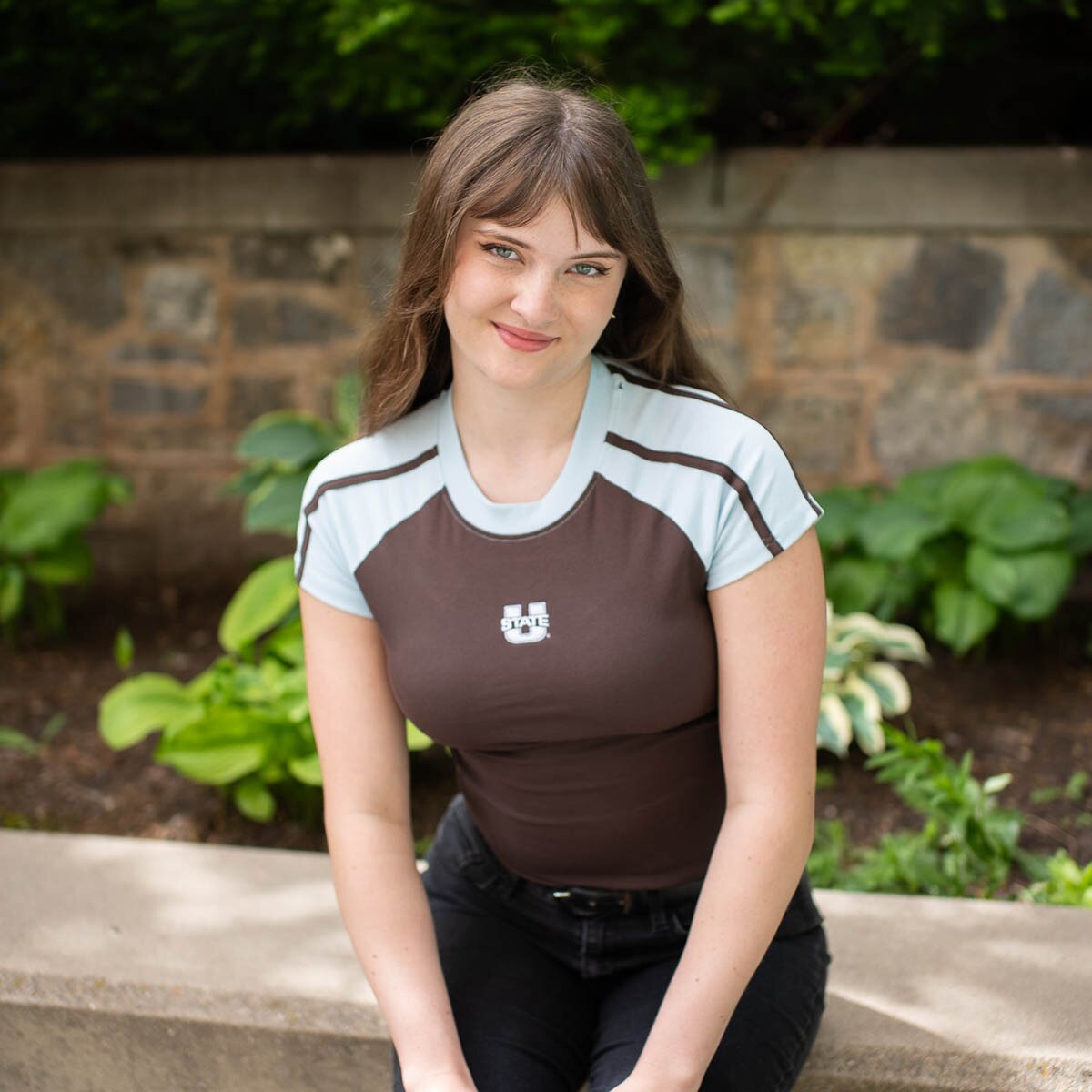 Young woman wearing brown and blue sporty fit u-state baby tee
